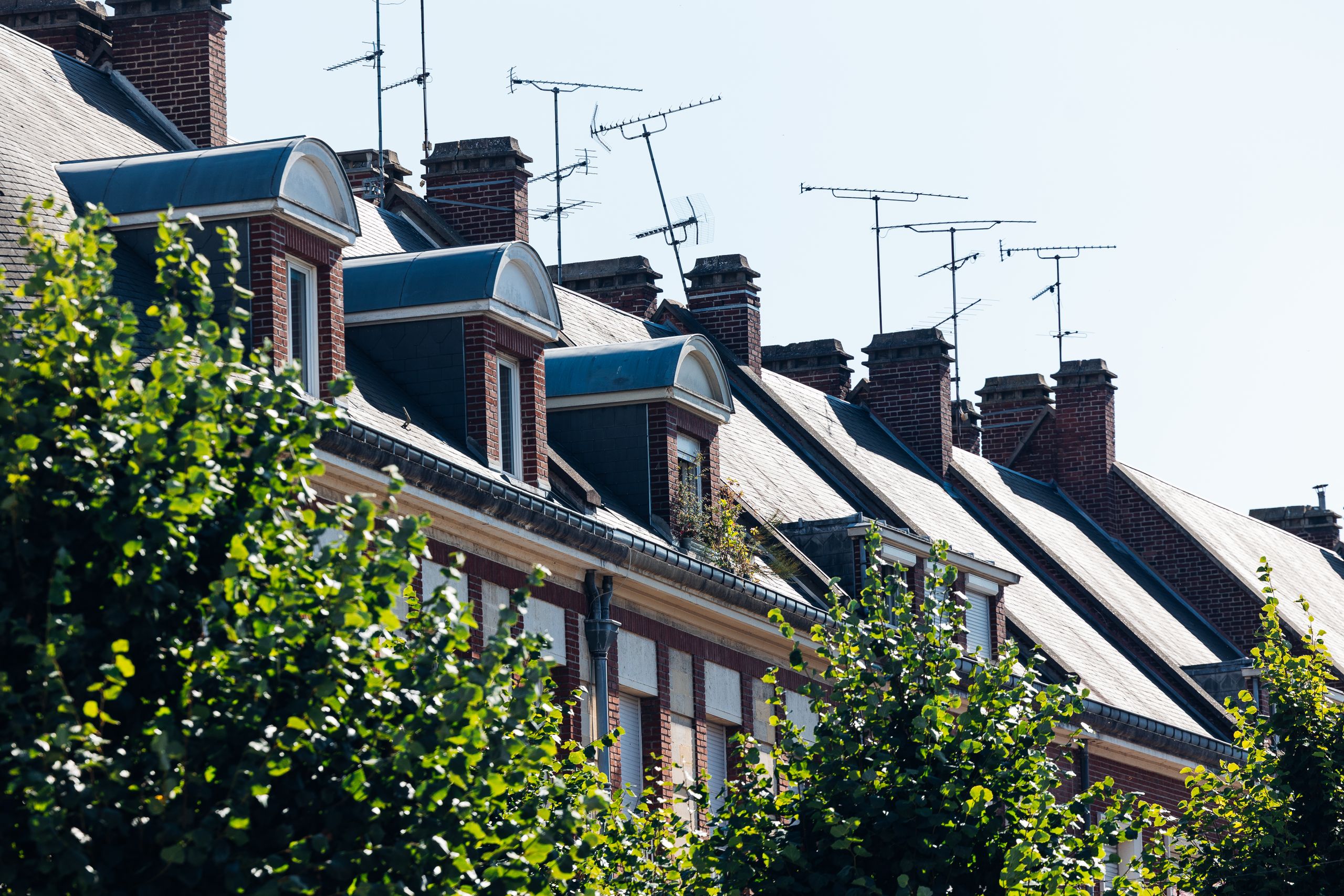 Charming rooftops and antennas in Amiens, showcasing classic French architecture on a sunny day.