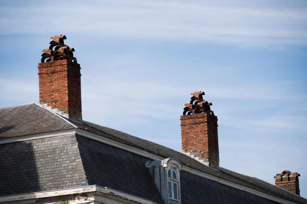 Cheminées en briques anciennes avec solins d’étanchéité sur toiture belge