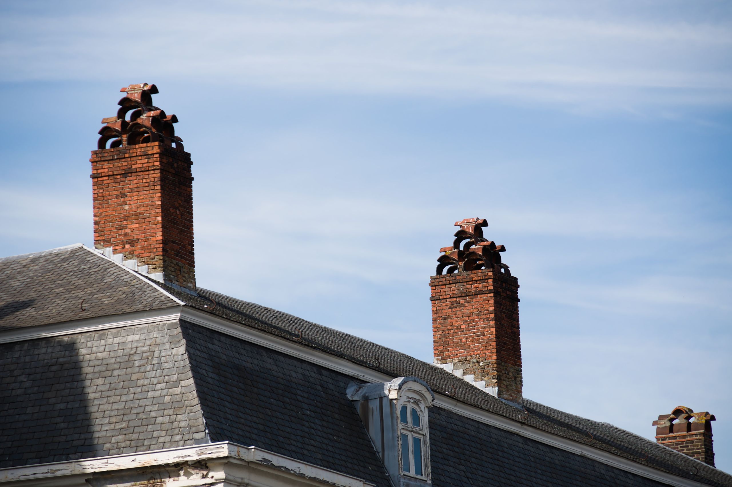 Cheminées en briques anciennes avec solins d’étanchéité sur toiture belge